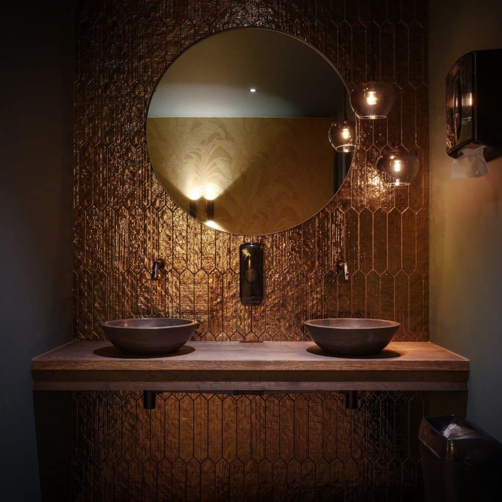 Luxe koperen details geven de badkamer een warme en stijlvolle uitstraling